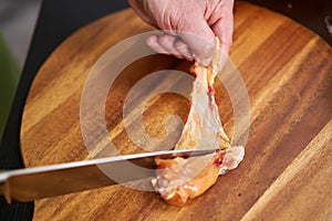 Cook removing skin from chicken wings