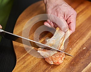 Cook removing skin from chicken wings