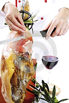 Cook's hands are slicing ham.