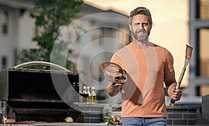 cook showcasing his barbecue techniques at cookout event. Man enjoying barbecuing. man grilling his favorite meats