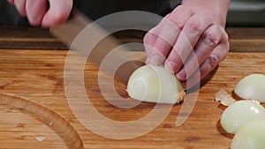 Cook slices onions on a cutting board. Slice, natural.