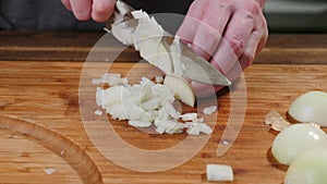 Cook slices onions on a cutting board. Slice, natural.