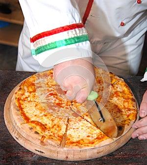 cook slicing pizza photo