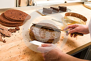 Cook spreading sauce on cake in kitchen