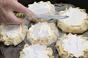 Cook spreads curd tart with sour cream before baking