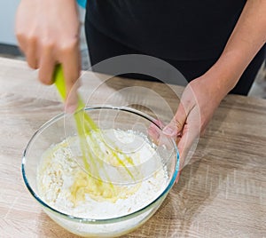 Cook stirring a cake dough in a bowl