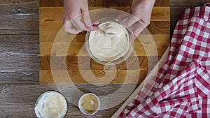 Cook stirs the sauce in a glass bowl