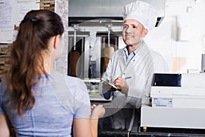 Cook taking order from customer in fast-food cafe