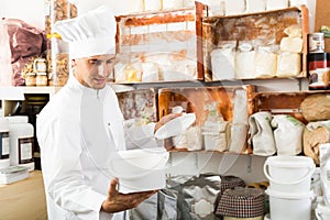 cook taking package with grit in pantry room.