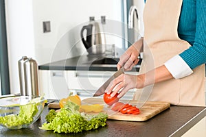 Cook woman cutting tomato salad knife kitchen