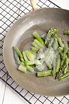 Cooked asparagus in a pan with sugar