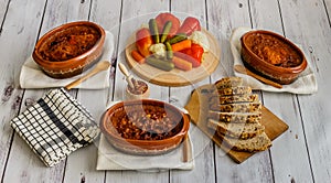 Cooked beans in clay pots, pickled vegetable and homemade bread