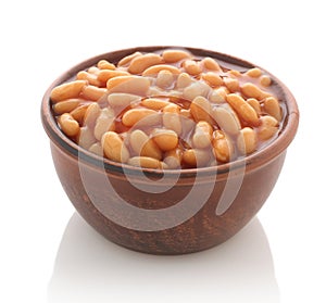 Cooked beans with red sauce in a clay bowl