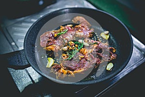 Cooked beef steak with rosemary and garlic inside iron skillet