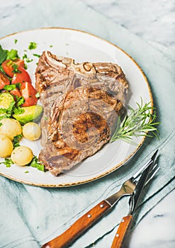 Cooked beef tbone steak with vegetables and fresh rosemary photo