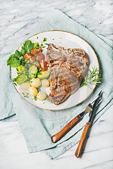 Cooked beef tbone steak with vegetables and rosemary