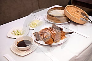 Cooked Beijing roast duck served on a plate in a restaurant.