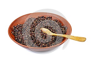 Cooked black quinoa in clay bowl with wooden spoon isolated on a white
