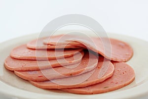 Cooked boiled ham sausage or rolled bologna slices