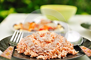 Cooked brown rice in plate with spoon and fork