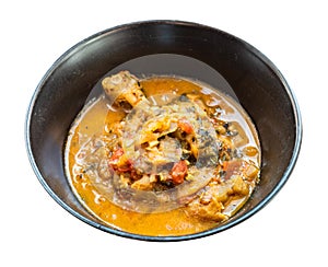 Cooked Chakhokhbili dish in black bowl cut out