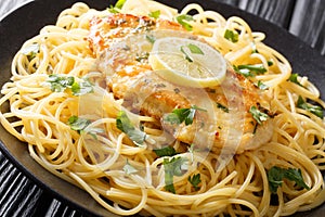 Cooked chicken Francaise with spaghetti in lemon wine gravy close-up on a plate. horizontal