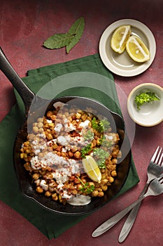 Cooked chickpea in frying pan with curry and spices, homemade vegan chickpeas, healthy food, colorful background