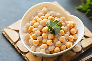 Cooked chickpeas in white bowl. Ingredient for Tasty vegetarian food. Boiled chickpeas, selective focus