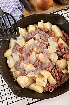 Cooked corned beef hash in a cast iron pan