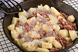Cooked corned beef hash in a cast iron pan