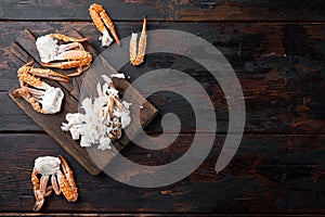 Cooked crab claws and legs meat, on wooden cutting board, on dark wooden background, top view flat lay  , with copyspace  and