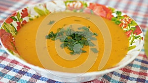 Cooked and decorated with greens pumpkin cream soup in a plate. Healthy food