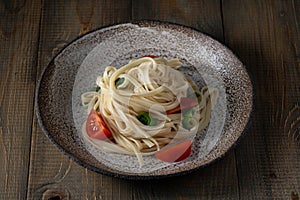 Cooked egg noodles with tomatoes and basil