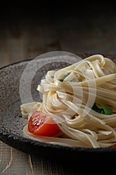 Cooked egg noodles with tomatoes and basil