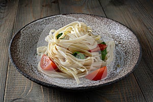 Cooked egg noodles with tomatoes and basil