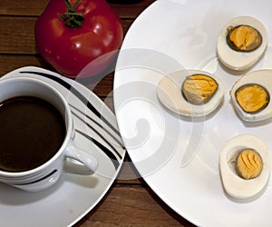 Cooked egg and tomato  on a wooden table