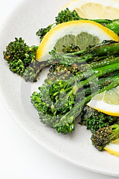 Cooked fresh broccolini with lemon on the plate