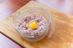 Cooked fresh mince for dish with raw egg lie in a plate