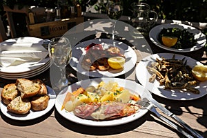 Cooked fresh red scorpionfish, grill shrimps, fried fresh anchovies in the greek tavern, tasty seafood lunch concept.