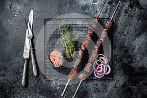 Cooked on the grill beef shish kebab with vegetables and spices, grileld meat. Black background. Top view