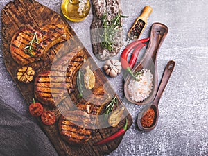 Cooked grilled meat pork, beef, chop on a bone, on a cutting board, spices