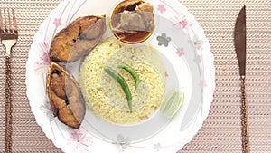 cooked ilsha fish and rice on plate on table