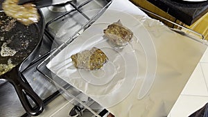 Cooked meat being transferred onto tinfoil