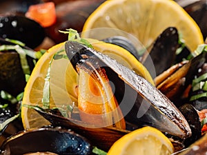 cooked mussels with lemon in white bowl