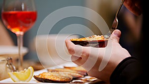 Cooked mussels served. A man eating the mussel with a fork