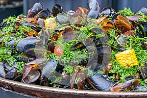 Cooked mussels shells with grilled corn, tomatoes and herbs