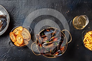 Cooked mussels with toasted bread and wine, shot from above