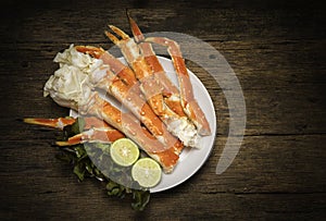 Cooked Organic Alaskan King Crab Legs with Butter and lemons, Alaskan King Crab on vintage wooden background.