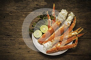 Cooked Organic Alaskan King Crab Legs with Butter and lemons, Alaskan King Crab on vintage wooden background.