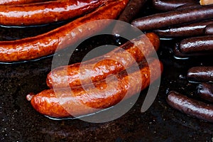 Paprika bratwurst sausages on cast iron griddle.